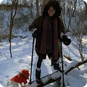 Woman Balancing on Fallen Tree with Crutches and a Dog