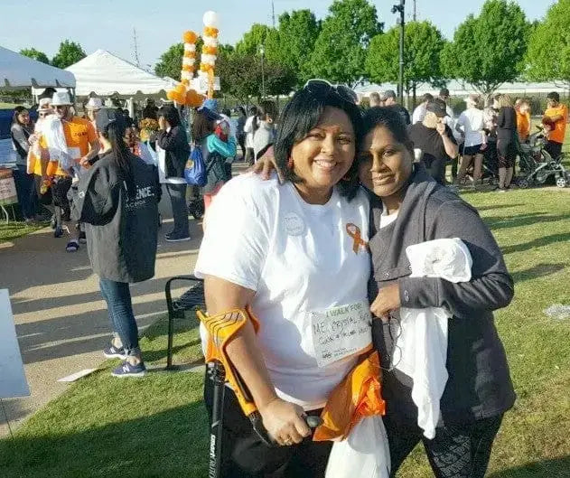 Two women posing at a gathering, one with her smartCRUTCH
