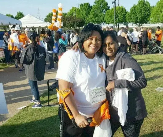 Two women posing at a gathering, one with her smartCRUTCH