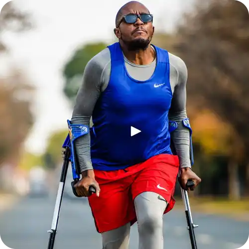 Athlete using crutches while wearing blue and red athletic clothing and sunglasses.